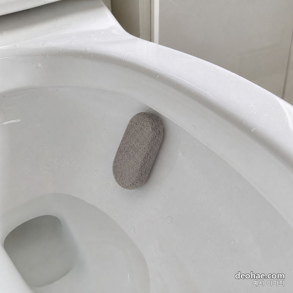 물을 묻힌 속돌로 요석을 갈아 내는 장면